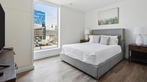 a bedroom with a bed and a large window at Landing at eXchange - Downtown Detroit in Detroit