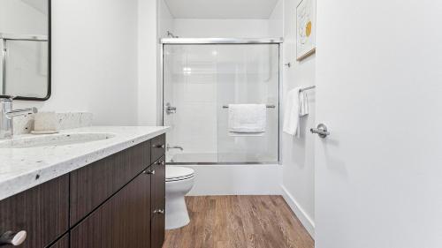 a white bathroom with a shower and a toilet at Landing at eXchange - Downtown Detroit in Detroit