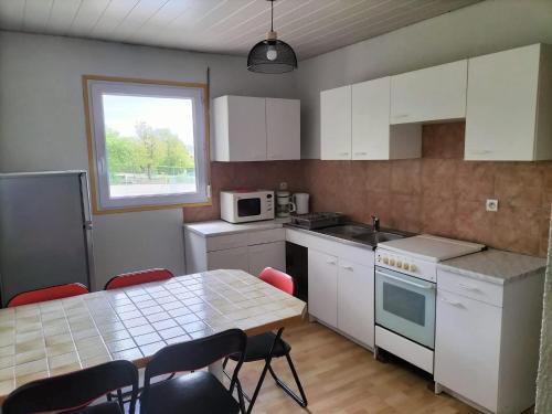 une cuisine avec une table et des chaises et une fenêtre dans l'établissement les lavandes, à Lablachère