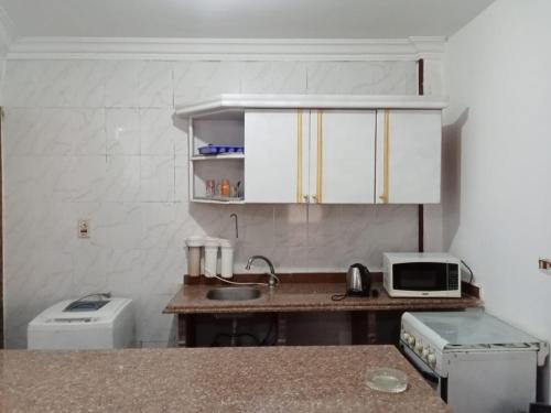 une cuisine avec des armoires blanches et un comptoir dans l'établissement 1B V150B Chalet 3bedrooms basement green beach, à El Alamein