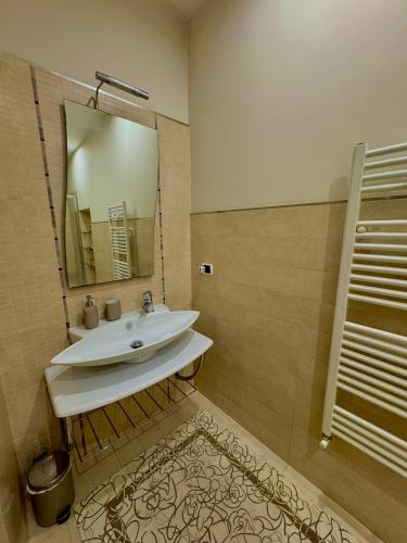 a bathroom with a sink and a mirror at Le More Apartment in Rutigliano