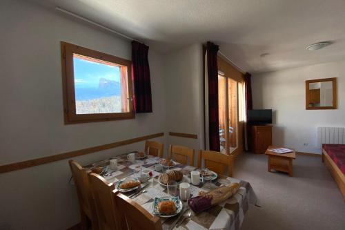 une salle à manger avec une table sur laquelle se trouve de la nourriture dans l'établissement Cosy nest near the SuperDévoluy ski resort, à Saint-Étienne-en-Dévoluy