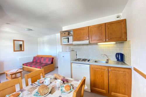 une cuisine avec une table et une cuisine avec une salle à manger dans l'établissement Cosy nest near the SuperDévoluy ski resort, à Saint-Étienne-en-Dévoluy