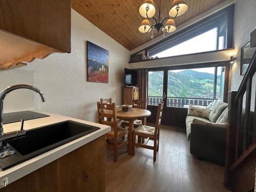 une cuisine et un salon avec un évier et une table dans l'établissement Richemont 12 - Duplex proche pistes vue, à La Clusaz