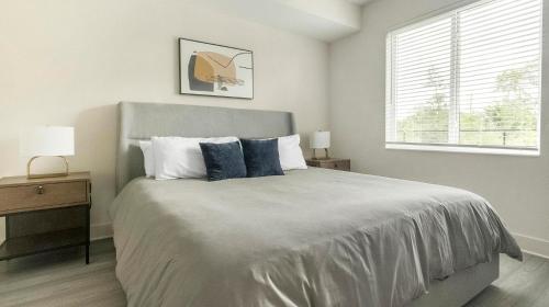 PalmettoにあるLanding Palmetto Apartmentsの枕が2つ付いたベッドと窓のある寝室