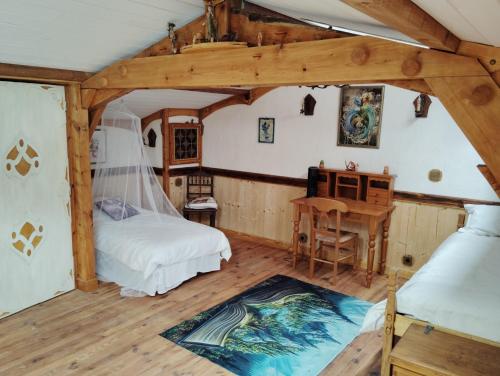 a bedroom with a bed and a desk in a room at Les Faes du Bos in Saint-Beauzire