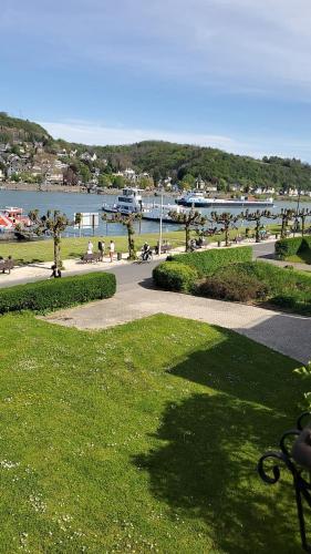 a park with a walkway next to a body of water at Wellness am Rheinufer in Remagen