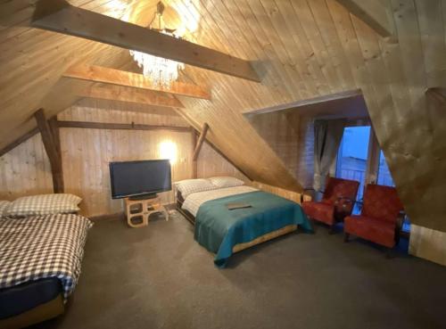 a bedroom with a bed and a tv and chairs at Studio 611 in Třebíč