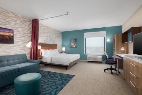 a hotel room with a bed and a couch at Home2 Suites By Hilton Virginia Beach Princess Anne in Virginia Beach