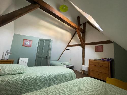a attic bedroom with two beds and a dresser at 2 gîtes mitoyens - 10 personnes - Jardin - Centre Saint Aignan in Saint-Aignan