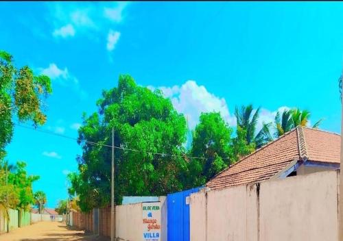 a fence next to a street with trees in the background at Mango garden villa in Pottuvil
