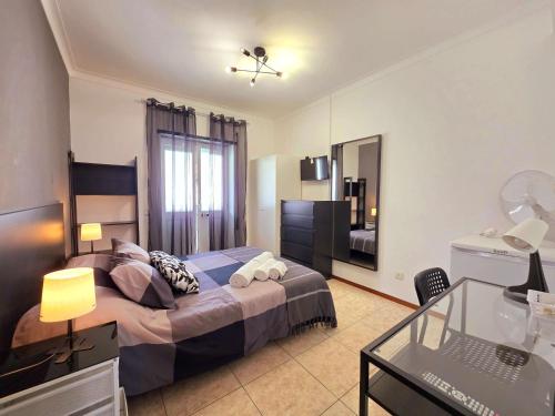 a bedroom with a bed and a desk and a mirror at Novas Direcões in Melgaço