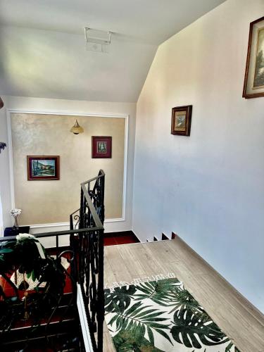 a room with white walls and a staircase with a bed at Pensiunea La Meleta in Şurdeşti