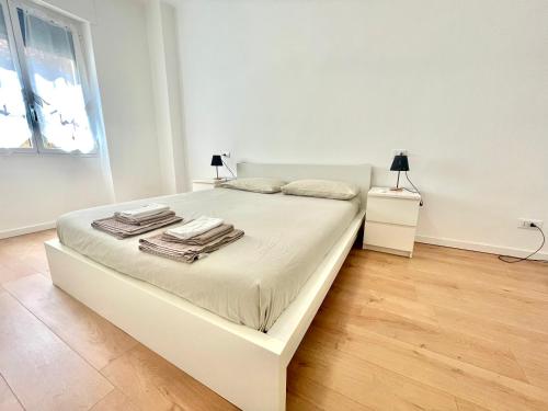 a white bedroom with a bed with towels on it at La casa di Mariposa in Sanremo