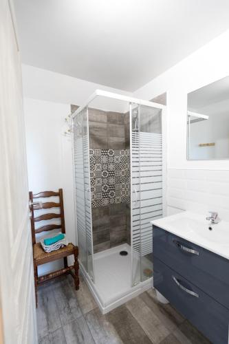 a bathroom with a shower and a sink and a chair at Terre d'Horizon Auvergne in Chastreix