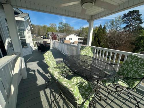 a patio with a table and chairs on a porch at Badin Shores Resort - Excellent Lake View Home - Pools & Lots of Amenities - Great Porch Area - Family in New London