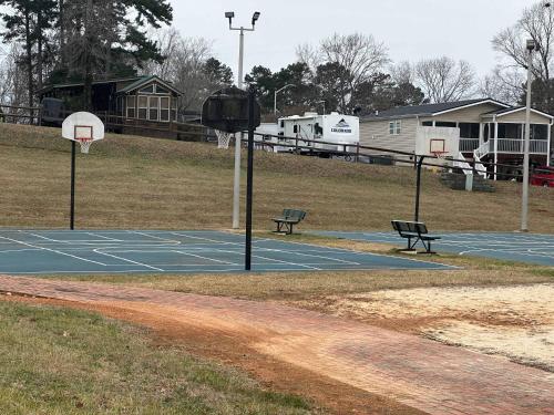 a basketball court with two benches and a basketball hoop at Badin Shores Resort - Excellent Lake View Home - Pools & Lots of Amenities - Great Porch Area - Family in New London