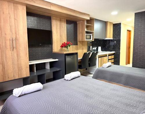 Habitación con 2 camas y cocina con encimera. en ALTURAS apart-hotel, en El Bolsón