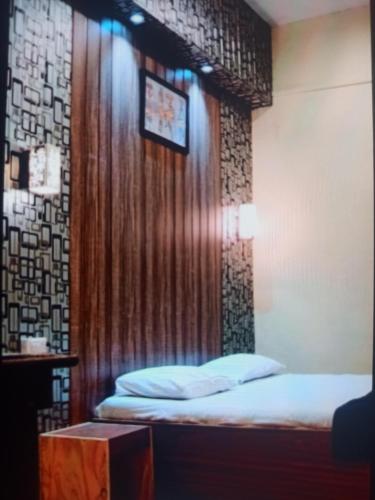 a room with two beds in a room with a wall at Kathiyawadi Resort park view matheran in Matheran
