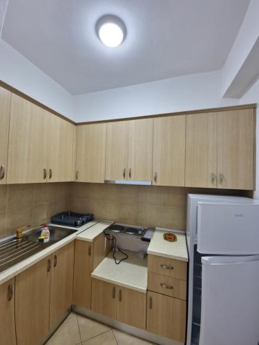 a kitchen with wooden cabinets and a white refrigerator at Villa Alvara in Vlorë