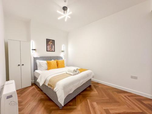 a bedroom with a bed and a ceiling fan at Modern 2 Bedroom Flat in Luton Town Centre in Luton