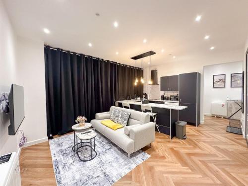 a living room with a couch and a kitchen at Modern 2 Bedroom Flat in Luton Town Centre in Luton