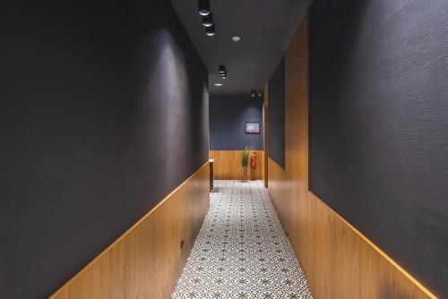 een gang met een zwarte muur en een witte tegelvloer bij HB Elementa Hotel in Tbilisi City
