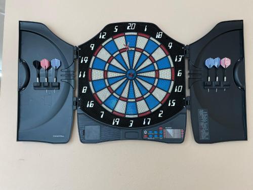 a dart board on a wall with two darts at Au Gré des Souvenirs, gite 4 à 10 pers, clim, jacuzzi, loisirs in Château-la-Vallière