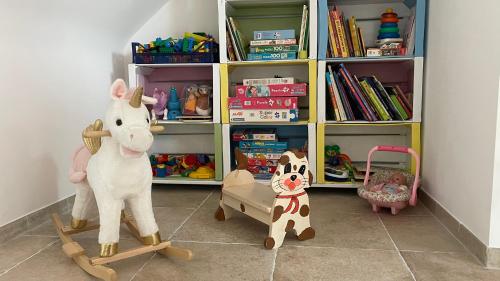 a room with stuffed animals and a book shelf at Au Gré des Souvenirs, gite 4 à 10 pers, clim, jacuzzi, loisirs in Château-la-Vallière