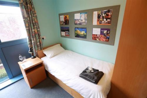 a small bedroom with a bed with a bag on it at Carrock Hall, University of Cumbria Carlisle in Carlisle