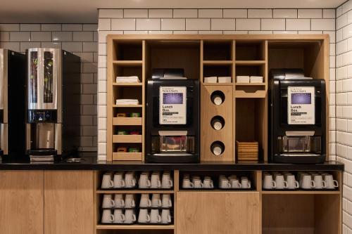 a store with two coffee machines on a counter at Holiday Inn Express London Limehouse by IHG in London
