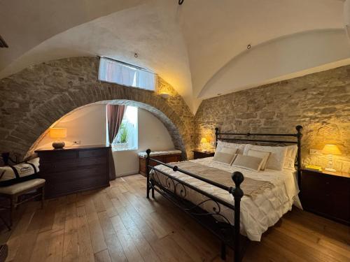 a bedroom with a bed and a stone wall at La Cripta - a due passi dalla Basilica - ItalyWeGo in Santa Maria degli Angeli