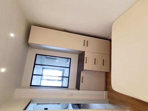 キブロンにあるAppartement proche de la grande plageの白いキャビネットと窓のあるキッチン