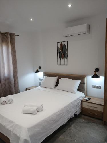 a bedroom with a large white bed with two towels on it at Διαμέρισμα με θέα in Agios Ioannis Kaspaka