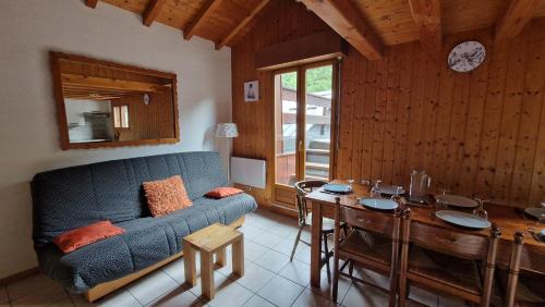 un salon avec un canapé bleu et une table dans l'établissement Demi-Chalet Le Bief --Prox pistes, aux Carroz d'Arâches