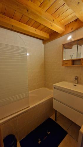 une salle de bain avec une baignoire et un lavabo dans l'établissement Demi-Chalet Le Bief --Prox pistes, aux Carroz d'Arâches