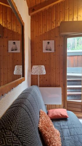 une chambre avec un lit avec un miroir et une fenêtre dans l'établissement Demi-Chalet Le Bief --Prox pistes, aux Carroz d'Arâches