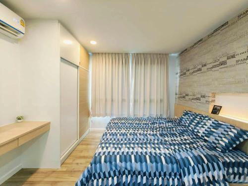 sypialnia z niebieskim łóżkiem i oknem w obiekcie Modern Cozy Suvarnabhumi w mieście Ban Khlong Prawet