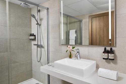 a bathroom with a sink and a shower at NH Madrid Balboa in Madrid