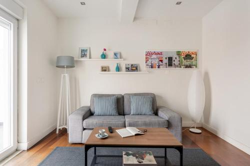 a living room with a couch and a coffee table at GuestReady - Modern flat near Estrela Garden in Lisbon