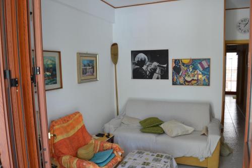 een slaapkamer met een bed en een stoel en foto's bij Villa Eugenia - Mondello Beach in Palermo