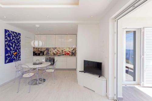 a kitchen and dining room with a table and a television at Blue Bay Residence in Hvar