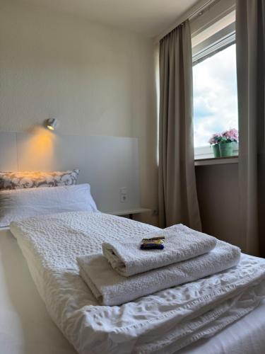 a bed with towels on it with a window at Hotel zur Post in Arnsberg