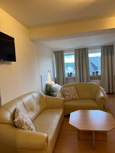 a living room with two couches and a table at Hotel zur Post in Arnsberg