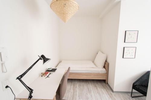 a small bedroom with a bed and a desk at Altstadt Suite in Weimar