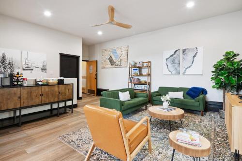 a living room with two green couches and a tv at Lift House Lodge, Close to Gondola, Premium Studio Condo in Vail