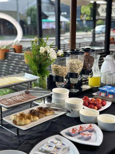 a table with plates of food on top of it at Hotel Boutique WenuPillan in Villarrica