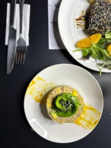 two plates of food with broccoli on a table at Hotel Boutique WenuPillan in Villarrica