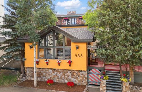 a house that is painted yellow at Lift House Lodge, Pet Friendly, Premium Studio Condo in Vail