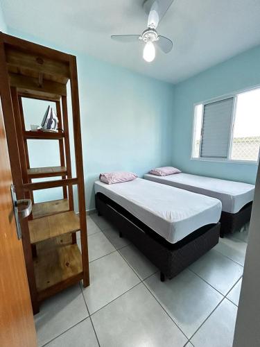 two beds in a room with a door open at Recanto Salgando a Alma in Ubatuba